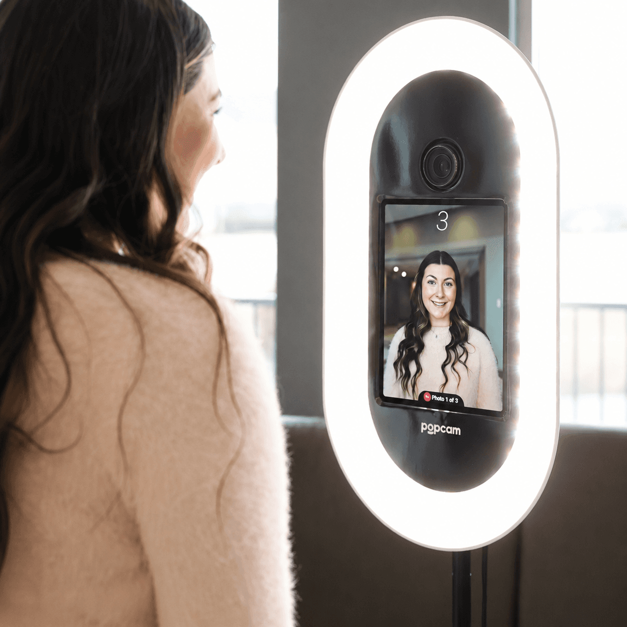 A guest taking a headshot at a Popcam kiosk