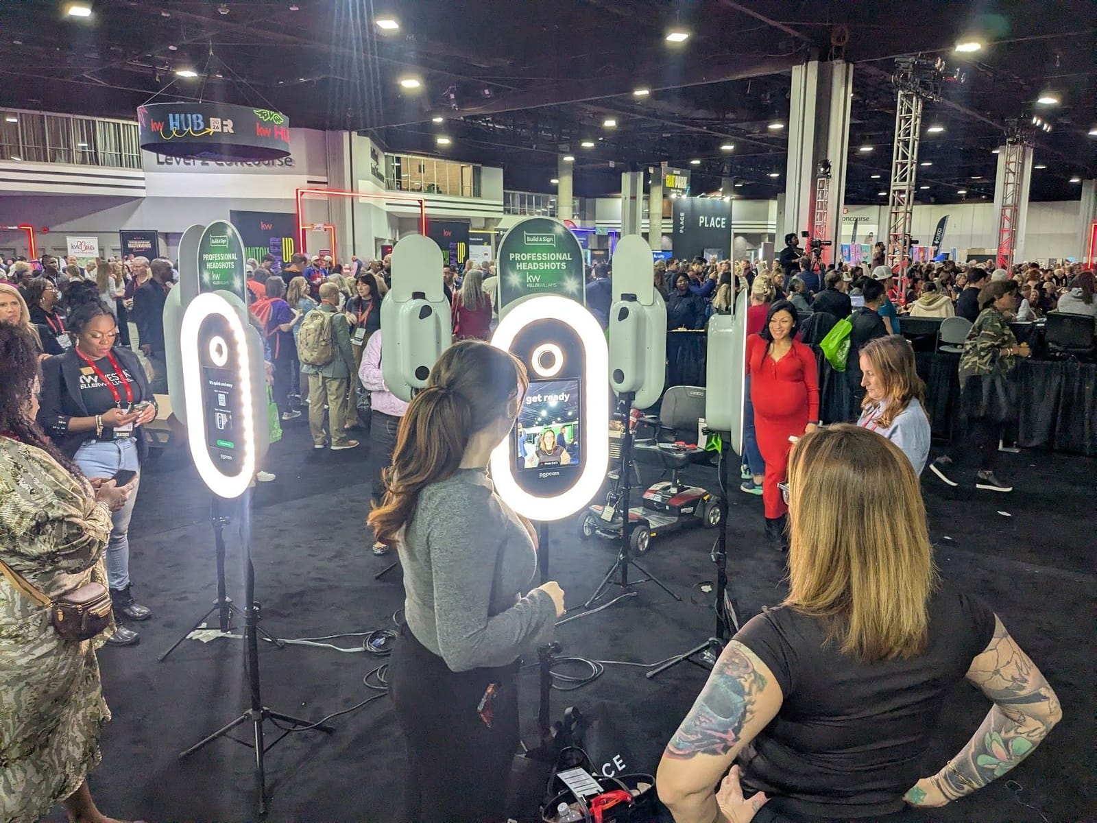 Attendees using Popcam kiosks at a Keller Williams conference headshot lounge